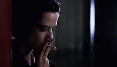 Woman smoking cigarette in dark room