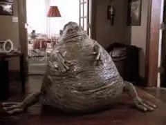 Frog monster waving from table