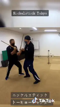 Two men practicing stick fighting