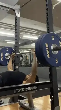 Man bench pressing heavy barbell