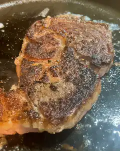 steak sizzling in pan
