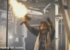 Man firing two guns in industrial setting