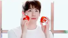 Man holding tomatoes near face