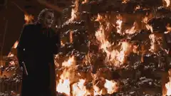 Joker standing by burning money
