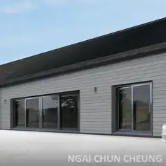 White Tesla driving past modern house