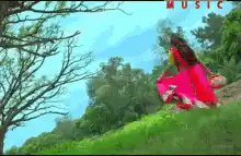 Woman in pink dress walking on grassy hill