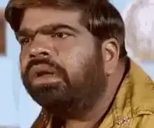Man in yellow shirt looking around confused