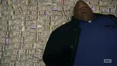 Big Hoss lying on a pile of money