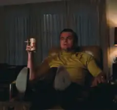Leonardo DiCaprio pointing while holding a drink