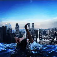 Person diving into pool with city skyline
