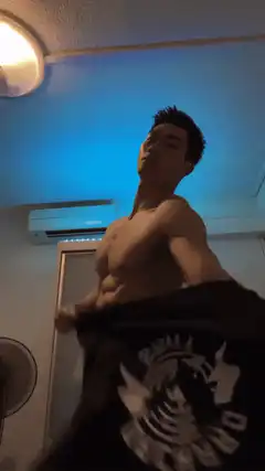 shirtless man taking off black t-shirt