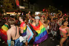 Pride parade crowd with rainbow flag
