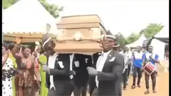 Dancing pallbearers carrying coffin