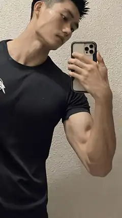 Man flexing bicep in mirror selfie