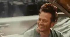 Sean Penn smiling in a car