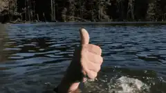 Thumbs up hand sinking in water