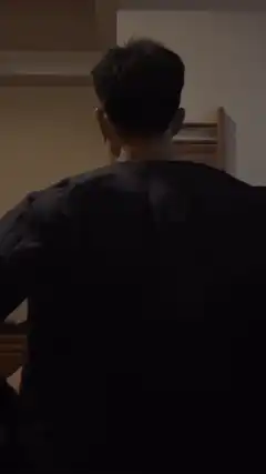 Man takes off shirt to show back muscles