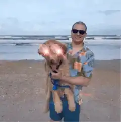 Man holding dog with glowing eyes and rainbow