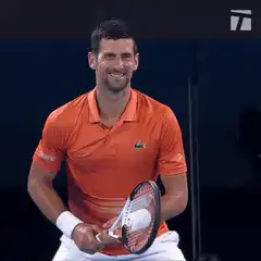 Novak Djokovic smiling with tennis racket
