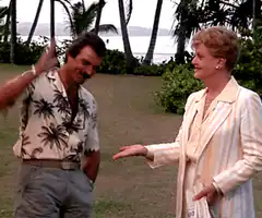 Man in Hawaiian shirt waves and bows