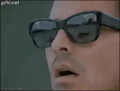 Man lifts sunglasses in shock