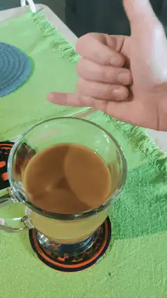 hand gives thumbs up over coffee