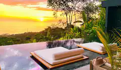 sunset infinity pool with lounge chairs