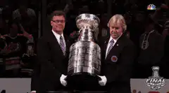 Men placing the Stanley Cup on a pedestal