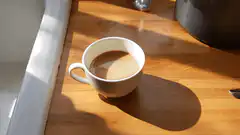steaming cup of coffee in sunlight