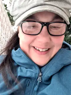 woman in hat and glasses smiling
