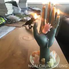 Hand shaped candle with burning fingers
