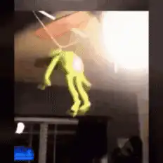 green alien toy falling from ceiling