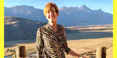 woman smiling in zebra print with mountains