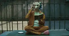 Harley Quinn reading and drinking in prison