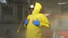 Person in yellow hazmat suit in car wash