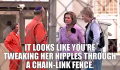Tweaking her nipples through a chain-link fence