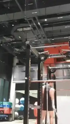 Muscular man flexes arm in gym