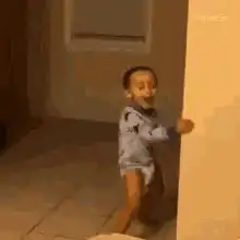 Toddler dancing behind a wall