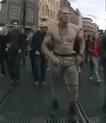 Shirtless man dancing on tram tracks