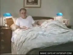 Old man pulls blanket over sleeping wife