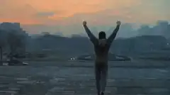 person raising arms at sunset