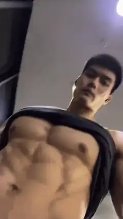 Man flexing abs in gym
