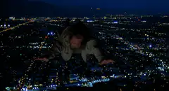 Bruce Willis flying over city at night
