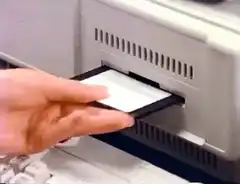 Family inserts floppy disk into computer