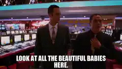 Two men in a casino looking at slot machines