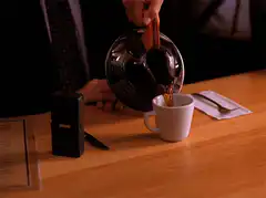 man pouring coffee into cup