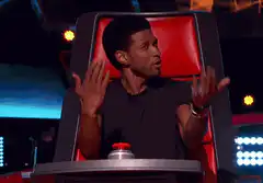 Usher shrugs in The Voice chair