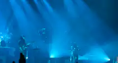 band performing on stage with blue lights