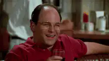 Jerry Seinfeld laughing and drinking