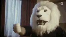 Lion man drinks coffee with a spoon